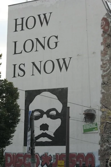 De tekst 'how long is now' staat geschreven op de zijkant van voormalig kunsthaus Tachelles. Vanwege de dreigende sluiting en de onzekere toekomst hebben kunstenaars de tekst op de zijkant van het gebouw geplaatst.